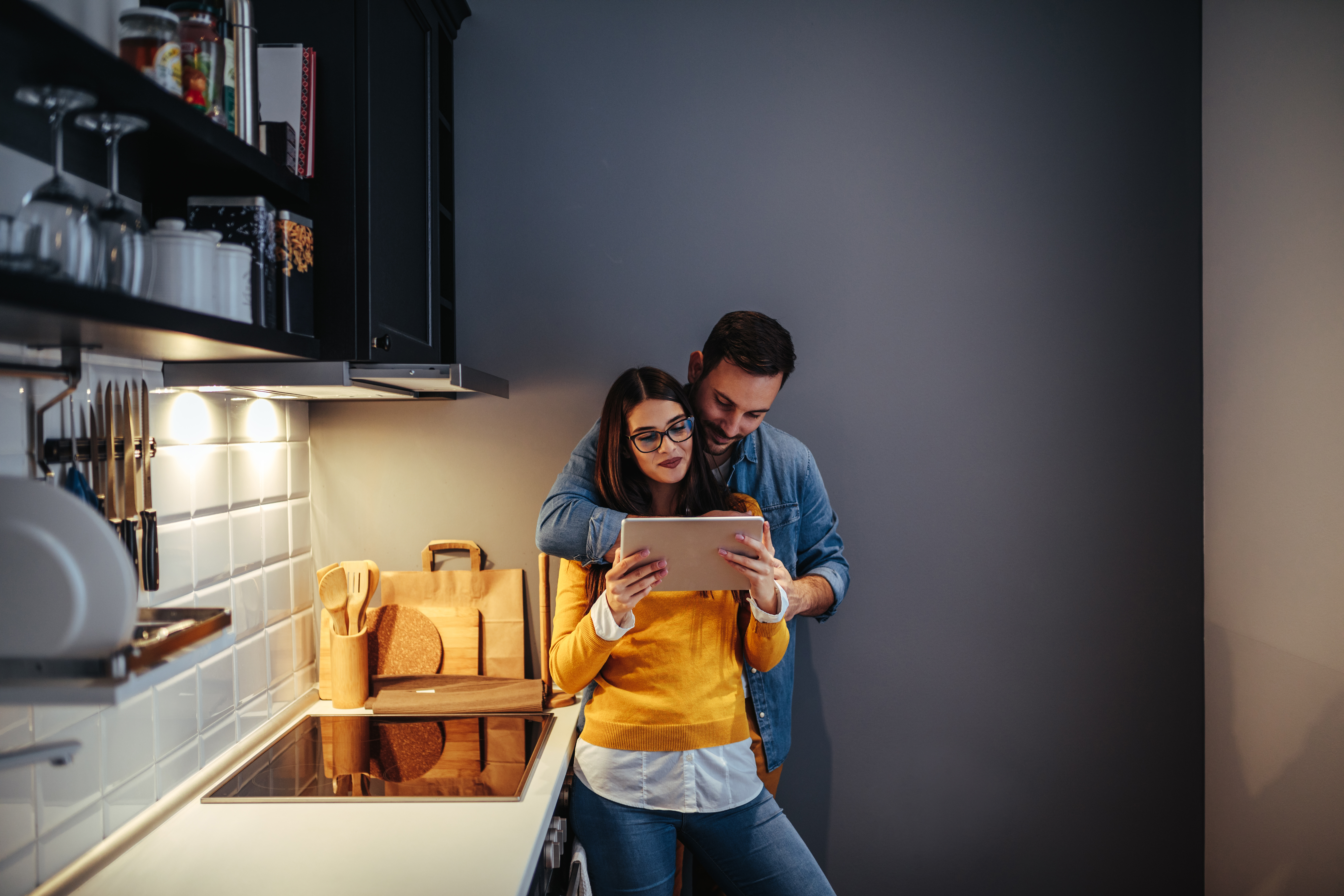 Pareja usando tableta en la cocina